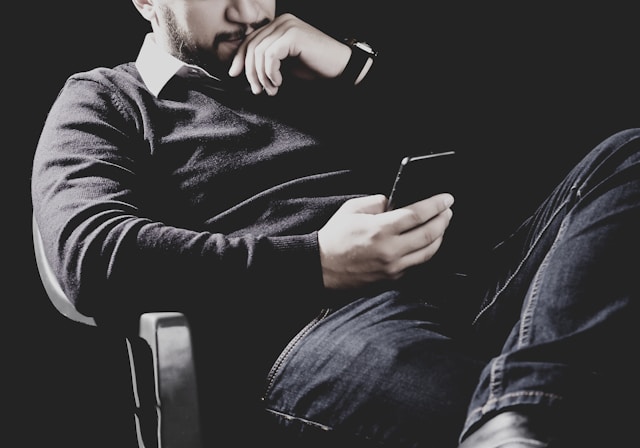 Person hält einsam ein Smartphone