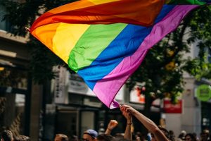 Regenbogenfahne wird auf einer Demonstration geschwenkt
